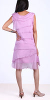 Woman wearing sleeveless light purple layered dress with frayed edges, back view