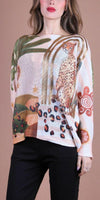 Woman wearing a lightweight knit sweater with cheetah and abstract nature print, paired with black pants