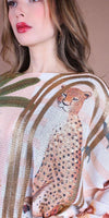 Woman wearing a lightweight knit top with cheetah and leaf print design