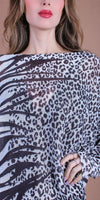 Woman wearing a loose-fit animal print top with black and white leopard pattern