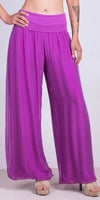 Woman wearing wide leg fuchsia silk pants with high waistband and platform sandals