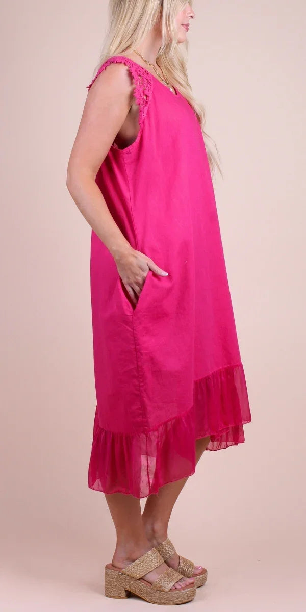 Sleeveless hot pink linen dress with lace trim and ruffle hem, modeled side view