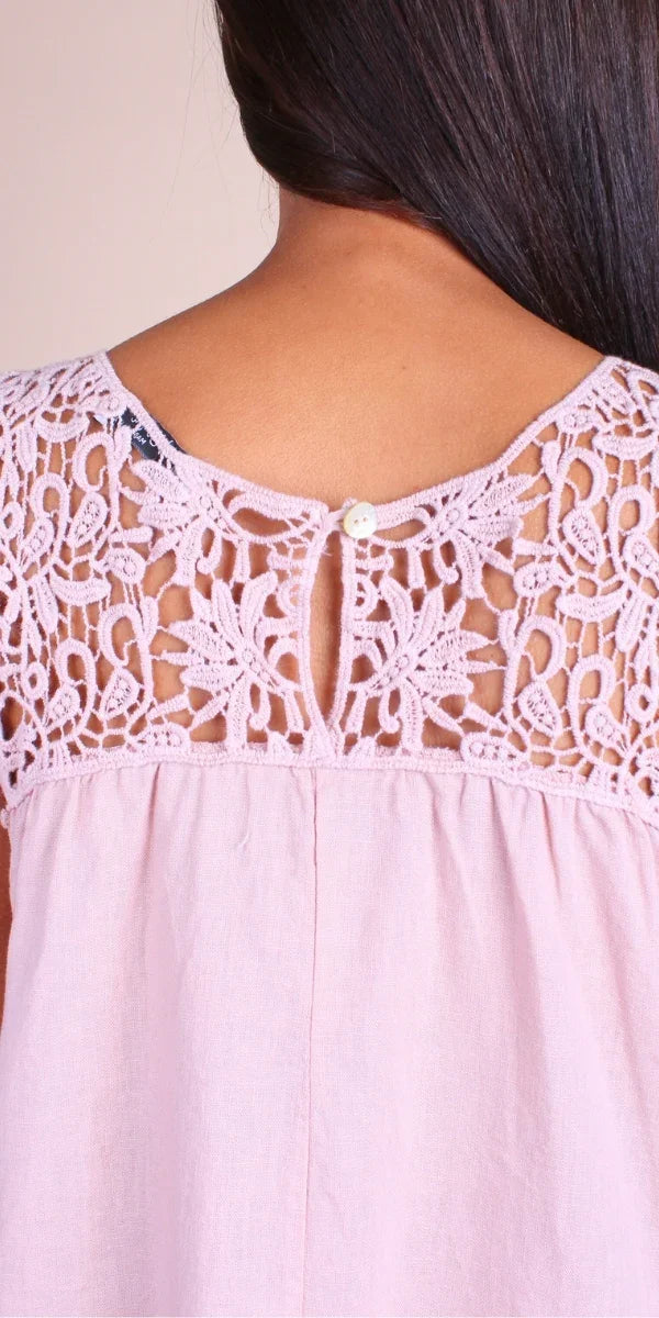 Close-up of pink linen dress with floral lace back detail and keyhole button closure