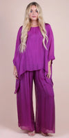 Woman in loose-fit purple silk top and wide-leg pants ensemble