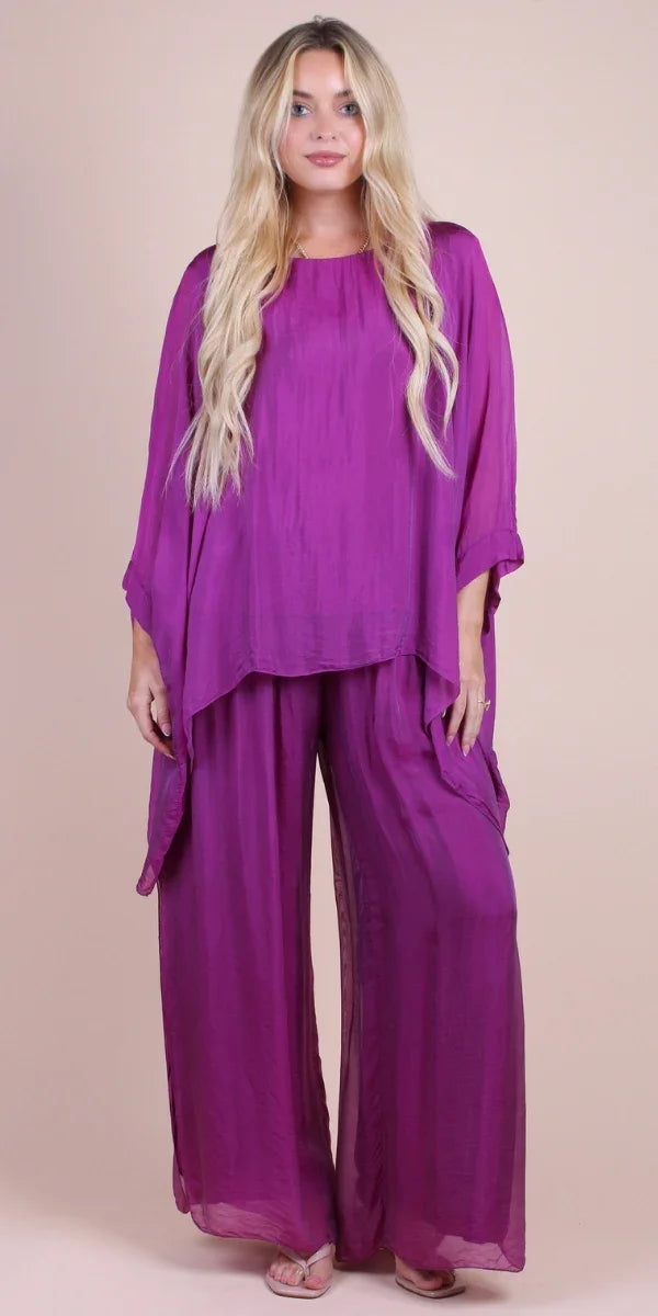 Woman in loose-fit purple silk top and wide-leg pants ensemble