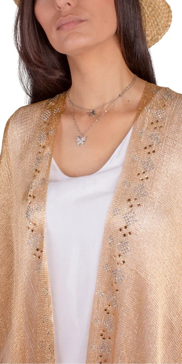 Woman in a golden fringe kimono, white outfit, brown heels, and straw hat