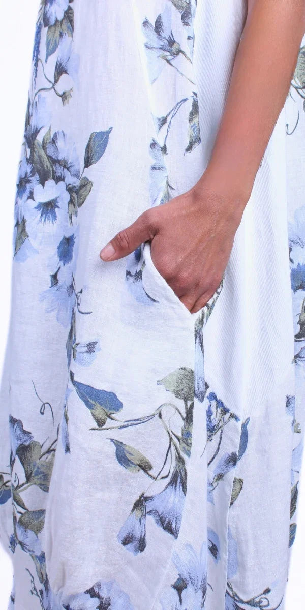 White floral linen dress with blue flowers and a pocket, close-up detail shot