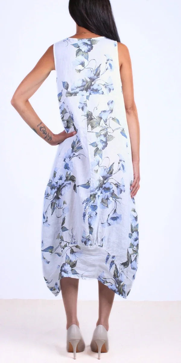 Back view of woman wearing sleeveless white floral linen dress and nude heels