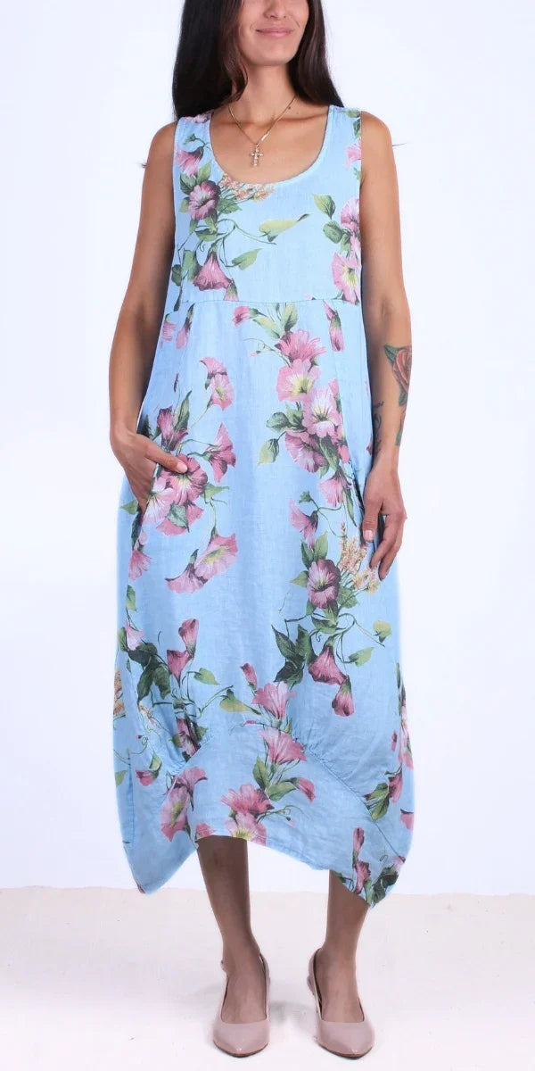 Woman in a sleeveless light blue floral linen dress with pockets