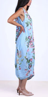Woman wearing sleeveless light blue floral linen dress with side pockets and nude heels