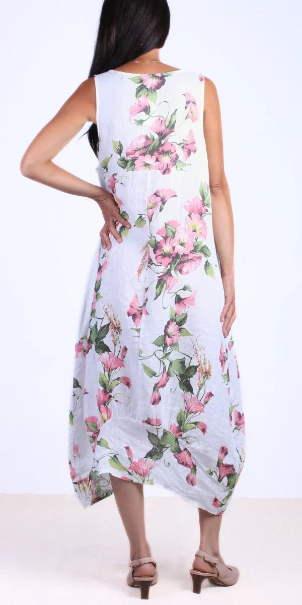 Woman wearing sleeveless white linen dress with pink floral print, back view