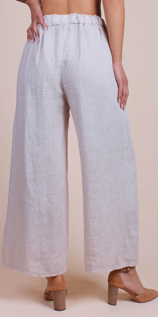 Back view of woman wearing wide-leg linen pants in light beige with high waist
