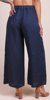 Woman wearing navy wide leg linen pants with elastic waistband and tan block heels