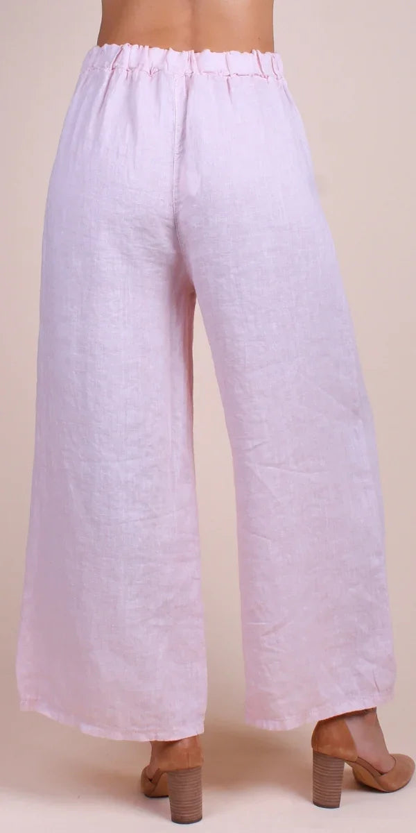 Back view of light pink linen wide leg pants with elastic waist, worn with heeled sandals