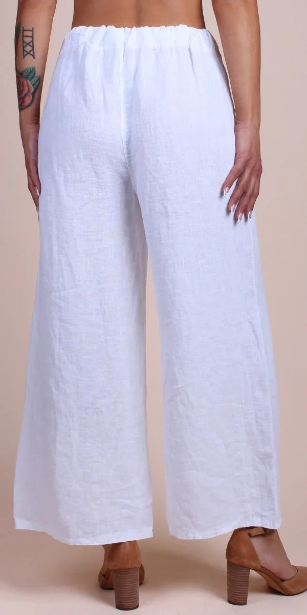 Back view of woman wearing white linen wide-leg pants with elastic waistband and block heels