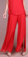 Woman wearing flowy red silk wide-leg pants and matching sleeveless top