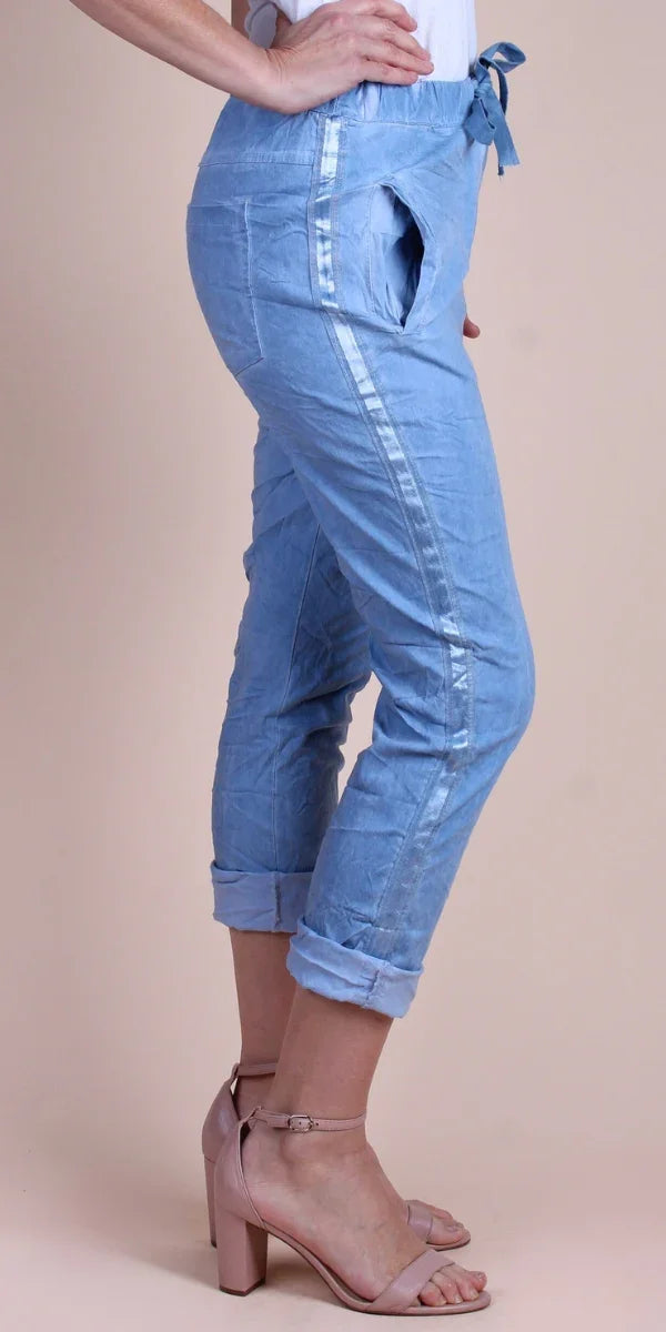 Light blue cropped pants with metallic side stripes, tie waist, and rolled cuffs on model