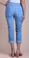 Woman wearing light blue cropped pants with back pockets and nude heels