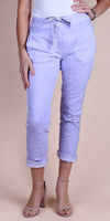 Woman wearing light purple drawstring linen pants with rolled cuffs and nude heels