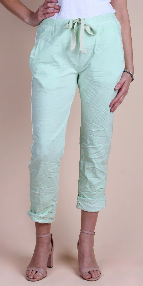 Women’s light green crinkle linen drawstring pants with rolled cuffs, styled with heels