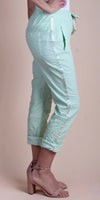 Light green cropped pants with side stripe, rolled cuffs, and side pockets on a model