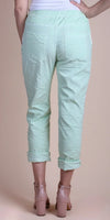 Back view of mint green cropped pants with cuffed hems, paired with nude block heels