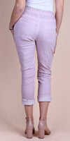 Back view of woman wearing light pink cuffed pants with patch pockets and nude block heels