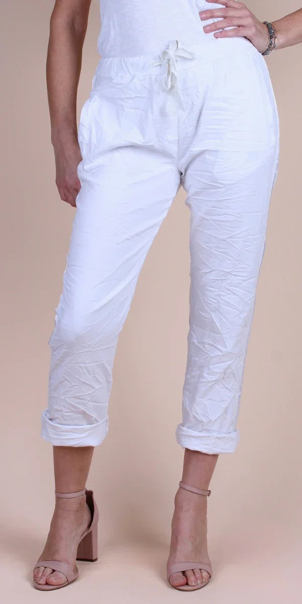 Woman wearing white drawstring cropped pants with rolled cuffs and nude heels