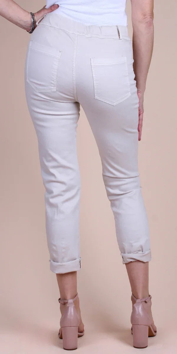 Back view of woman wearing light beige cropped pants with rolled cuffs and pink block heels