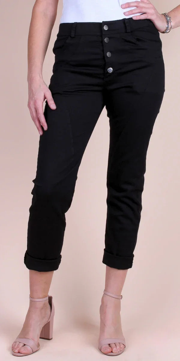 Black high-waist ankle pants with button fly, cuffed hem, paired with nude heels