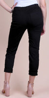 Back view of woman wearing black cropped pants with rolled cuffs and pink block heels