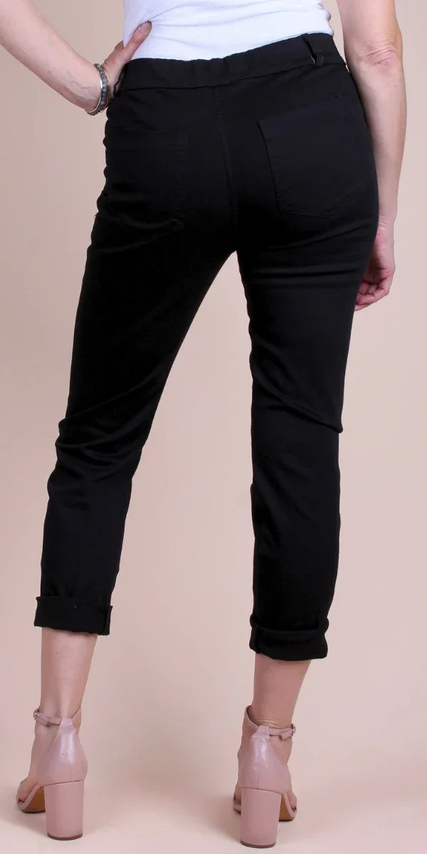 Back view of woman wearing black cropped pants with rolled cuffs and pink block heels