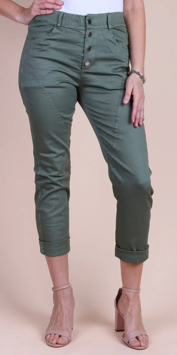 Woman wearing olive green high-waisted cropped pants with rolled cuffs and button front