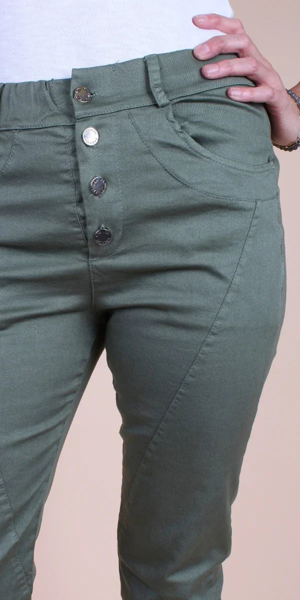 Close-up of olive green high-rise women’s pants with four silver buttons and front pockets