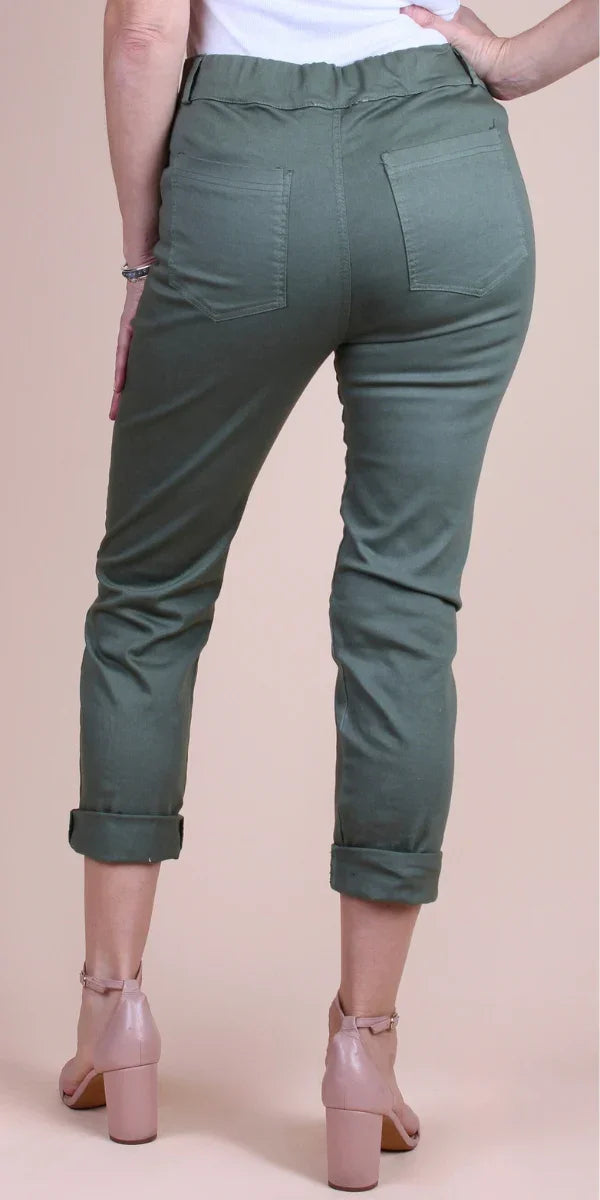 Woman wearing green cropped pants with cuffed hems and back pockets, paired with nude heels