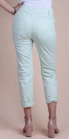 Back view of woman wearing light mint green cropped pants with rolled cuffs and nude heels