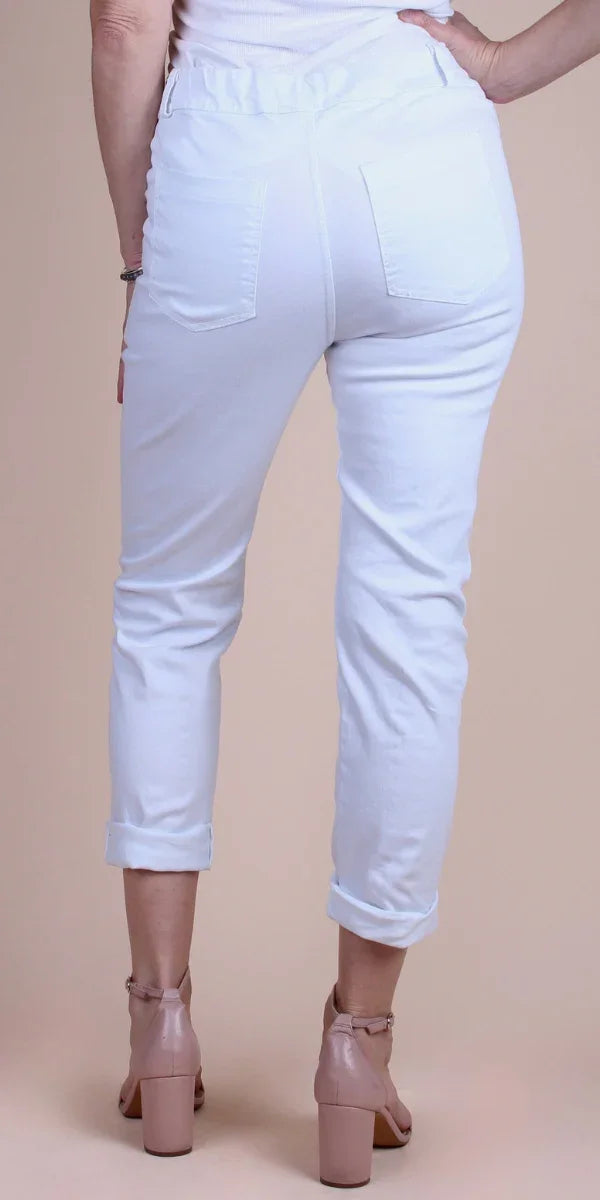 Back view of woman wearing white cropped pants with rolled cuffs and blush block heels
