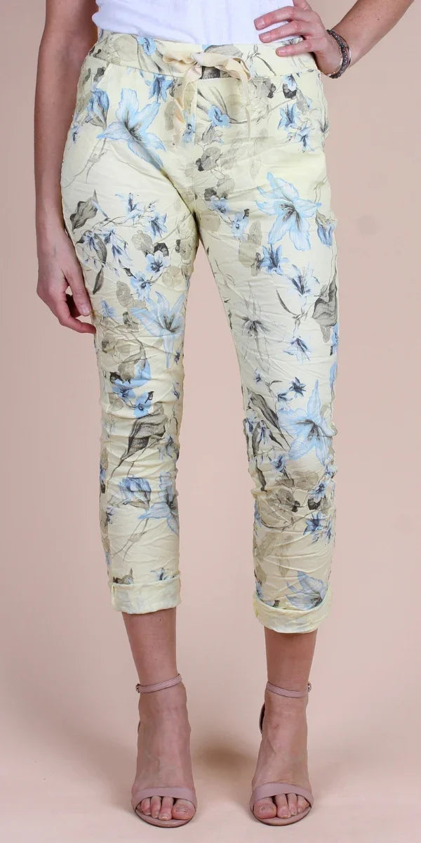 Women’s cropped floral pants in pastel yellow with blue and beige flower print and drawstring waist