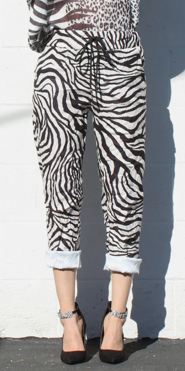 Black and white zebra print drawstring pants with rolled cuffs, styled with black heels
