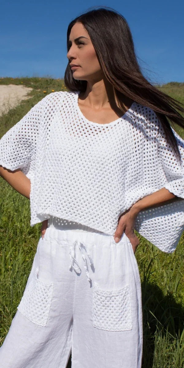 Woman outdoors in white crochet top and linen pants with patch pockets