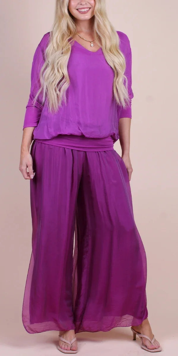 Woman wearing a loose-fit purple silk blouse and wide-leg pants set