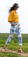 Woman wearing yellow linen shirt and floral print pants outdoors, stylish fashion look