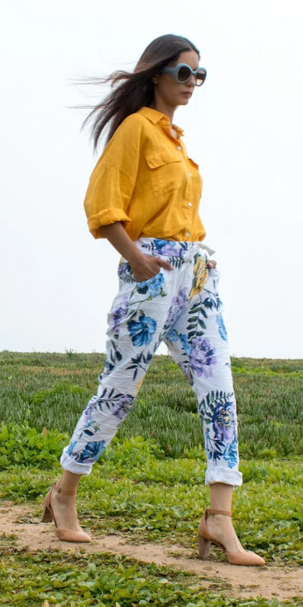 Woman wearing yellow linen shirt and floral print pants outdoors, stylish fashion look