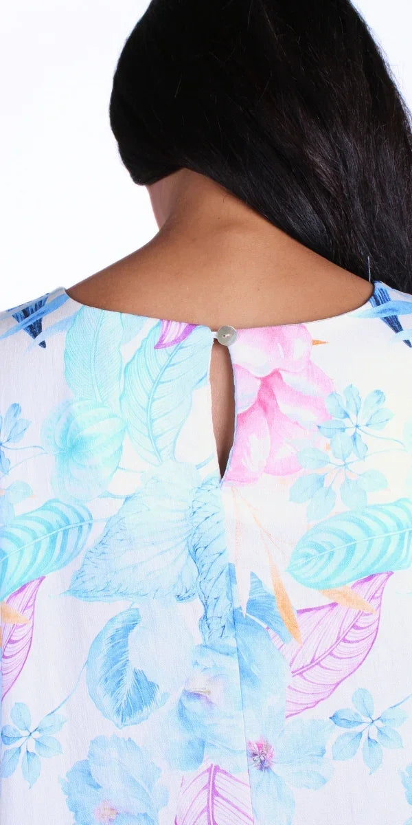 Close-up back view of a woman wearing a pastel floral blouse with a keyhole button detail