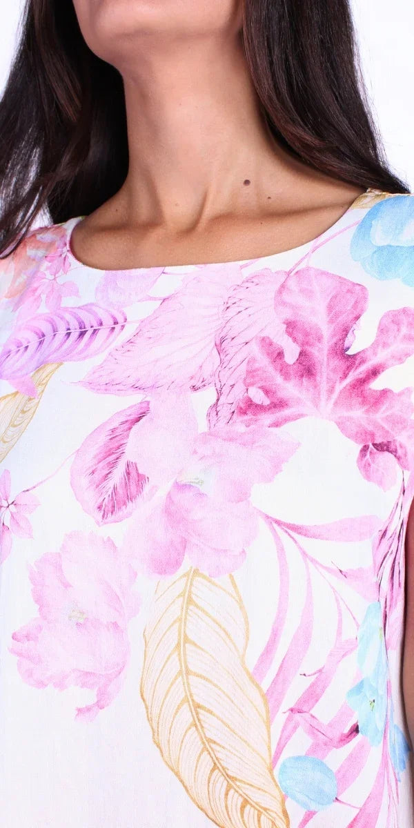 Close-up of a woman wearing a white top with colorful floral print and boat neckline