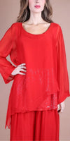 Woman wearing a sheer red silk blouse with sequin details and wide sleeves