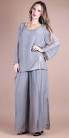 Woman wearing loose light gray silk top and wide-leg pants set, neutral background