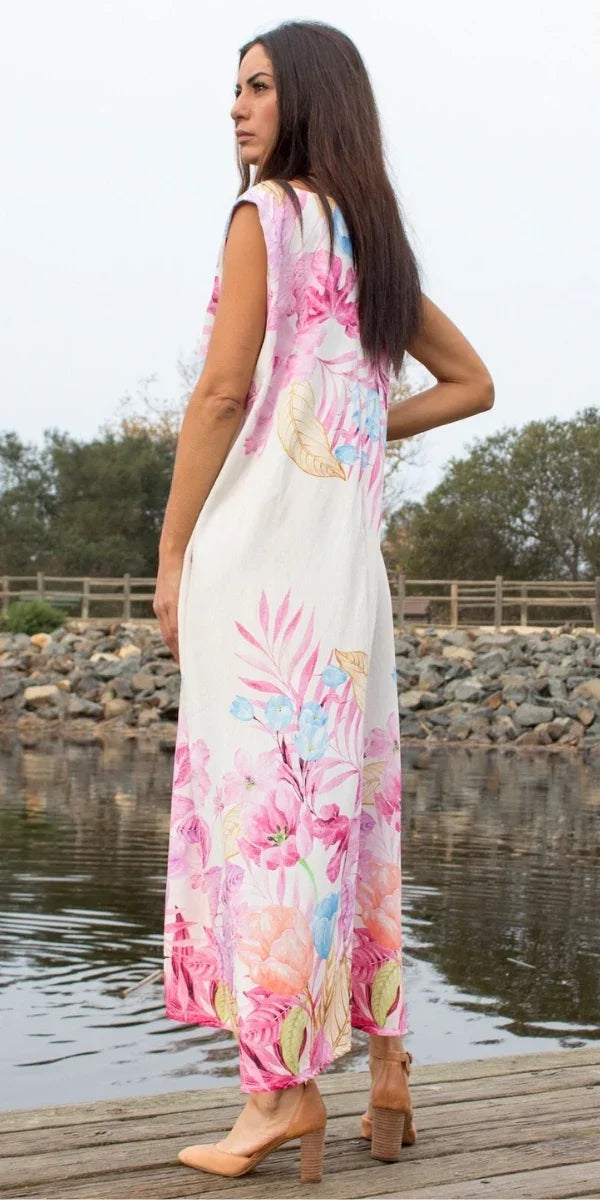 Woman in floral print maxi dress with pink and blue flowers, standing by a lake