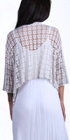 Back view of woman wearing a white crochet lace shrug over a white dress