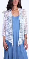 Woman wearing a white crochet lace cardigan over a blue sleeveless dress